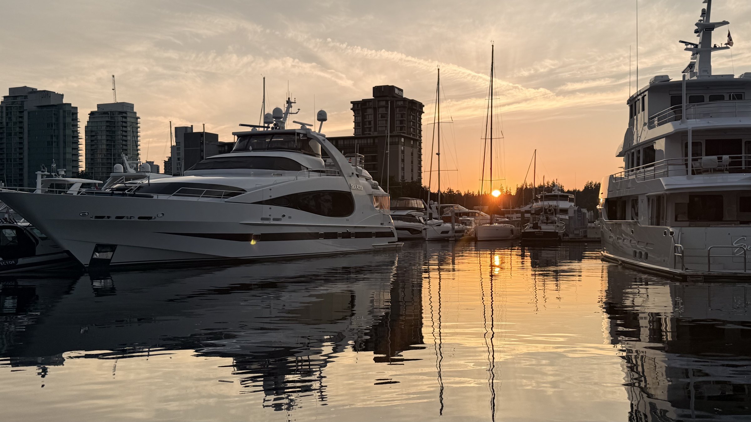 Yachts at Coal Harbour, Vancouver, at sunset with the city behind